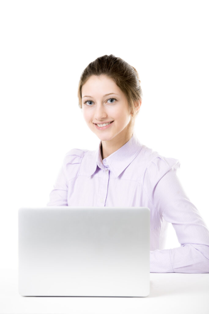 young smiling girl sitting in front of laptop